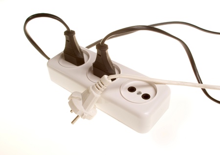 9517027 - three white and black electrical plugs into white outlet on the white